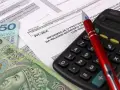 Formularz PIT-28/A, polskie banknoty i kalkulator. Czas rozliczyć podatek od najmu mieszkania.