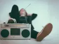 Osoba leży z nogami opartymi o boombox, słuchając muzyki. Idealny sposób, by sprawdzić, jak głośno można słuchać muzyki w dzień.