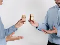 Dwie osoby trzymają miniaturowe domki, symbolizujące zniesienie współwłasności gdy współwłaściciel nie żyje.
