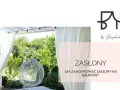 Białe zasłony na balkonie w bloku tworzą przytulną atmosferę. Widać huśtawkę i zieleń.
