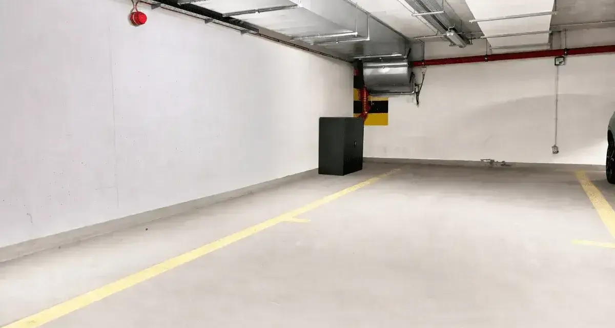 Puste miejsce parkingowe z żółtymi liniami. Idealne do wynajem miejsca parkingowego dla Twojego samochodu.