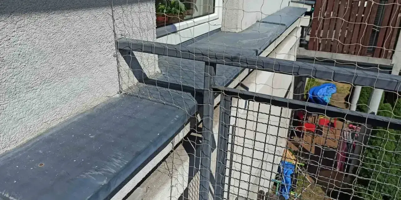 Siatkowanie balkonu cena: siatka zabezpiecza przed wypadnięciem, idealna dla kotów. Widok z góry na siatkę i balustradę.