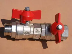 Metalowy zawór kulowy z czerwonymi rączkami, kluczowy element instalacji wodnej, stanowiący główny zawór wody w mieszkaniu.