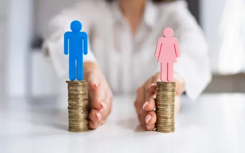 Rozdzielność majątkowa a wspólne konto: dwie stosy monet z figurkami mężczyzny i kobiety, symbolizujące podział finansów lub ich wspólne zarządzanie.