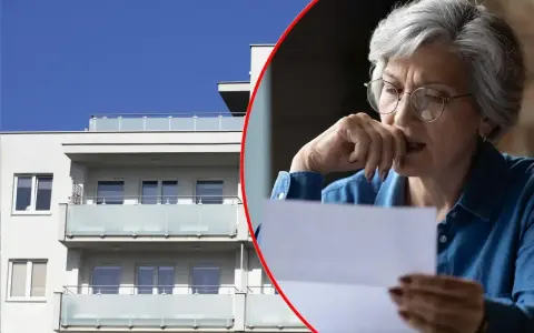 Zmartwiona starsza kobieta czyta list obok nowoczesnego bloku mieszkalnego. Czy to oznacza, że odstąpię mieszkanie TBS?
