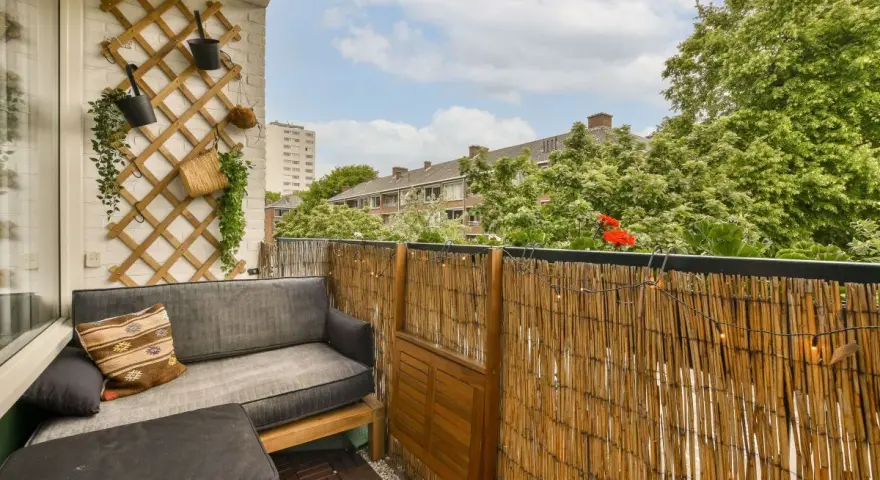 Bambusowa mata to świetny sposób, by czym osłonić balkon. Dodaje przytulności i prywatności, a wiszące lampki tworzą nastrojowy klimat.