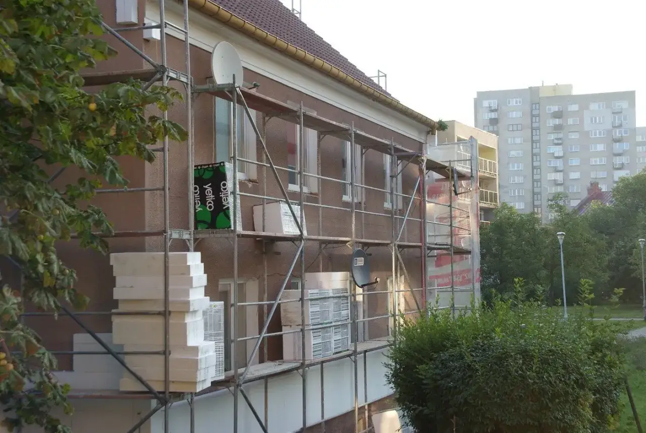 Rusztowanie przy budynku, materiały do ocieplenia. Brak zgody sąsiada na ocieplenie budynku uniemożliwia prace.
