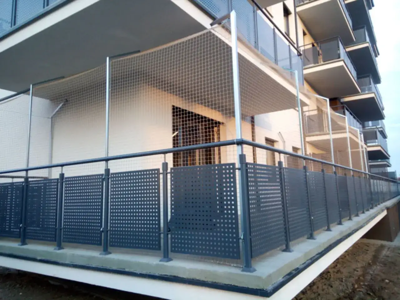 Siatkowanie balkonu cena: siatka zabezpieczająca balkon przed ptakami i kotami, nowoczesne balustrady z perforowanymi panelami.